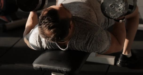 Άντρας ανύψωσης αλτήρες σε ένα γυμναστήριο κάνοντας άσκηση για θωρακικούς μυς — Αρχείο Βίντεο