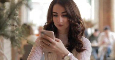 Woman messaging in cafe
