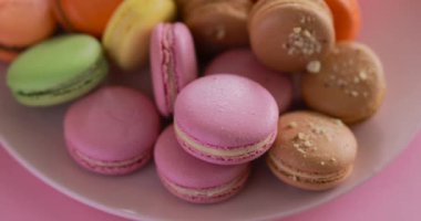 Female hand take one pink macaroon