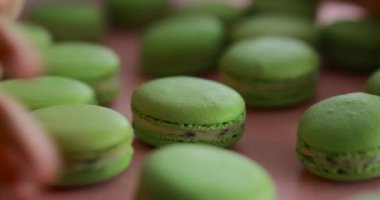 Kadın eli bir sürü yeşil badem kurabiyesi alır.