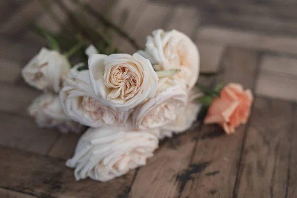 Světle růžové růže na dřevěné podlaze — Stock fotografie