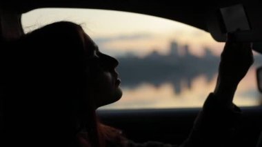 Woman corrects her hair in the car