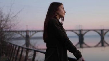 Woman looking forward at cityscape sunset thinking about future