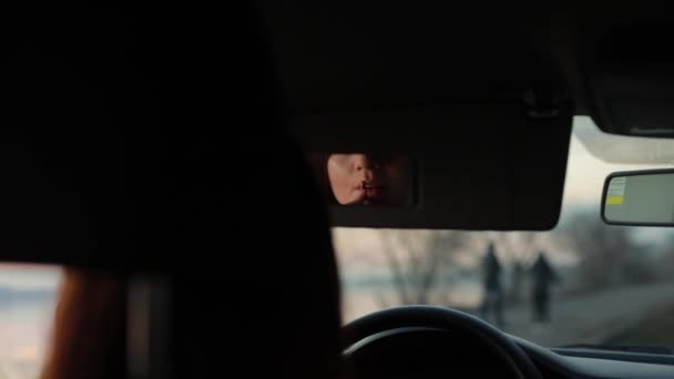 Женщина красит губы в машине — стоковое видео
