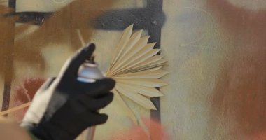 Painting wall with stencil in palm leaf shape