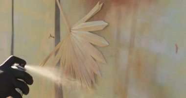 Painting wall with stencil in palm leaf shape