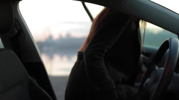 Женщина садится в машину и смотрит в окно — стоковое видео
