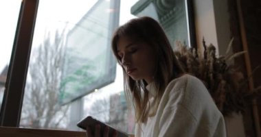 Young woman listening her favorite music with earphones in cafe