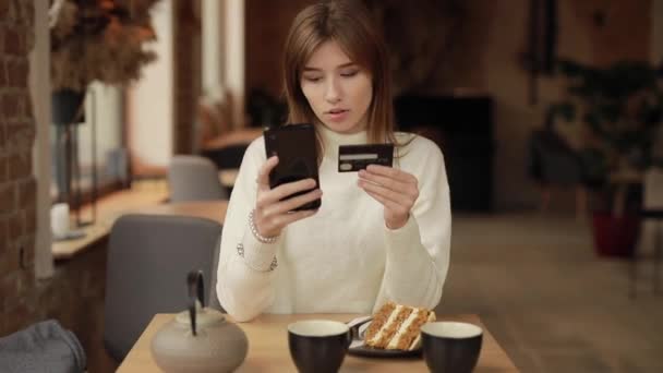 Женщина делает покупки онлайн с помощью кредитной карты в кафе — стоковое видео