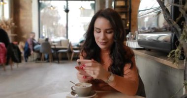 Woman laughing sitting in cafe leaning head on hand