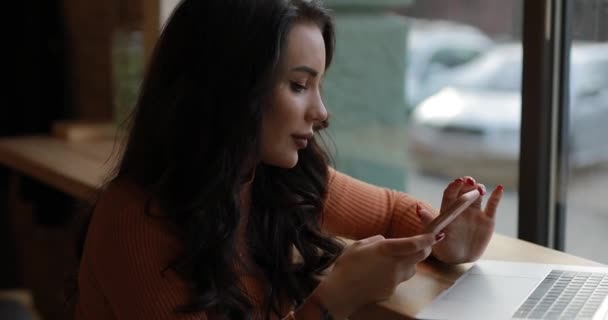 Woman sitting in social network near cafe window — Stock video