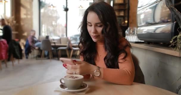 Woman using smartphone in cafe and laughing — Stok video