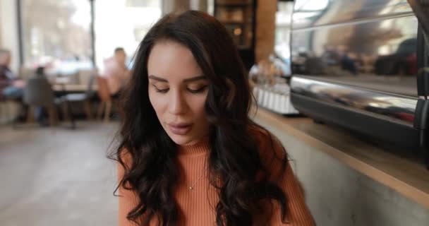 Retrato de mujer sonriente en la cafetería apoyada cabeza a mano — Vídeo de stock