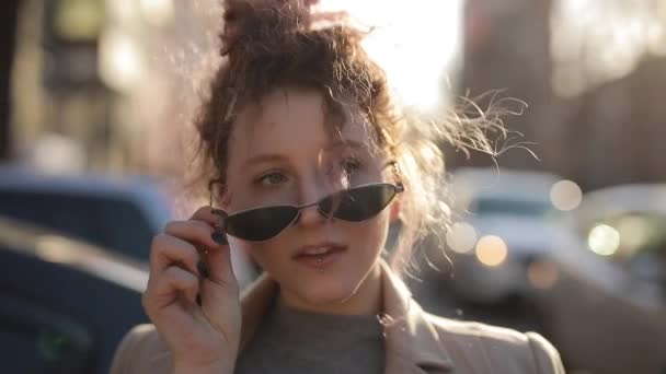 Незвичайний портрет кокетки в сонцезахисних окулярах у місті — стокове відео