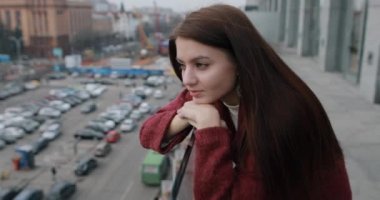 Woman relaxing looking at the city standing on terrace