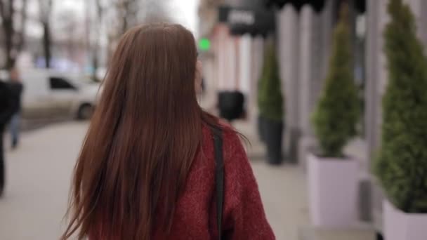 Модная женщина ходит по городу, меняя лицо — стоковое видео