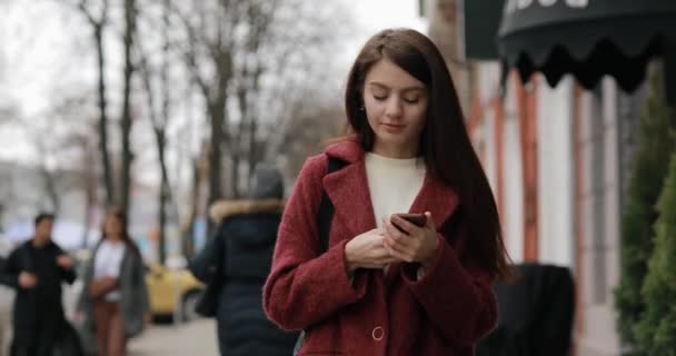 Ділова жінка використовує смартфон на ходу — стокове відео