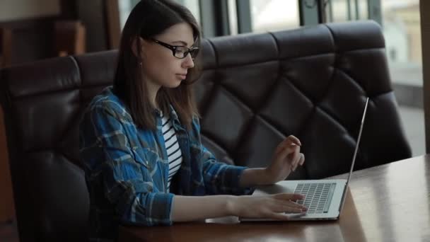 在咖啡馆用笔记本电脑工作的妇女 — 图库视频影像