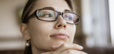 Myopia, woman looking through optical eyeglasses
