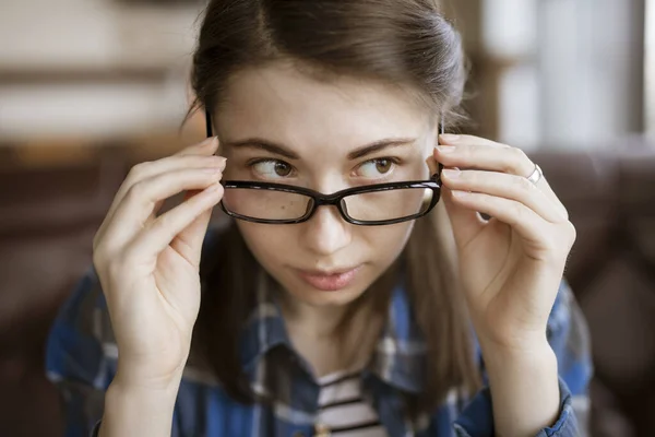 Miopía, mujer pruébate anteojos ópticos — Foto de Stock