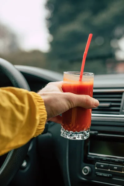 Man driver holding tomato juice in a car — 스톡 사진