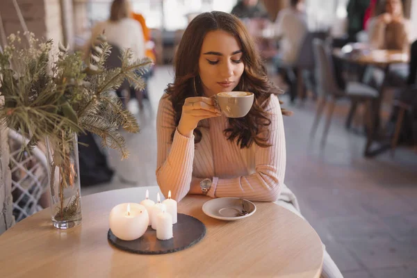Portrett av en ung kvinne som drikker kaffe på en kafe – stockfoto