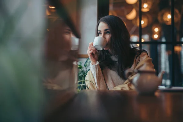 ผู้หญิงสาวดื่มชาในคาเฟ่มองผ่านหน้าต่าง — ภาพถ่ายสต็อก