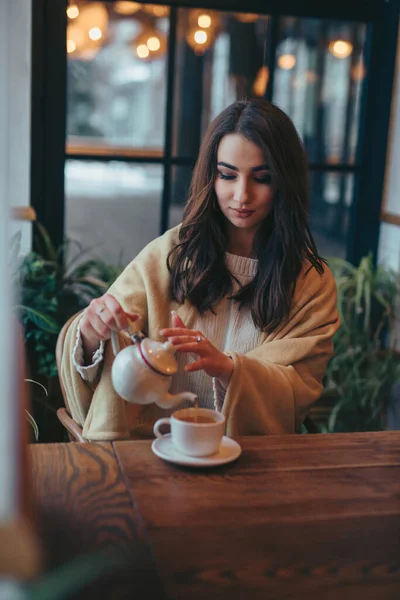 Kvinne som heller te i kopp – stockfoto