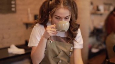 Cute barista woman taste brewed coffee