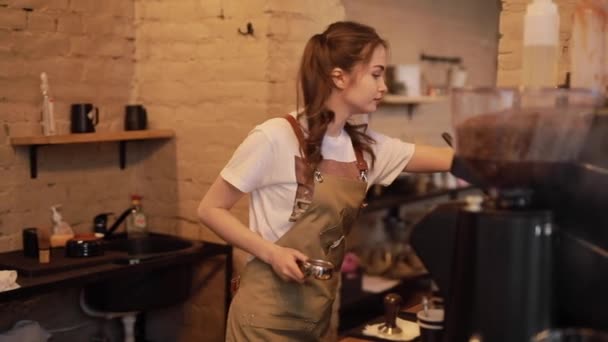 Young and cheerful barista woman make a coffee — Stockvideo