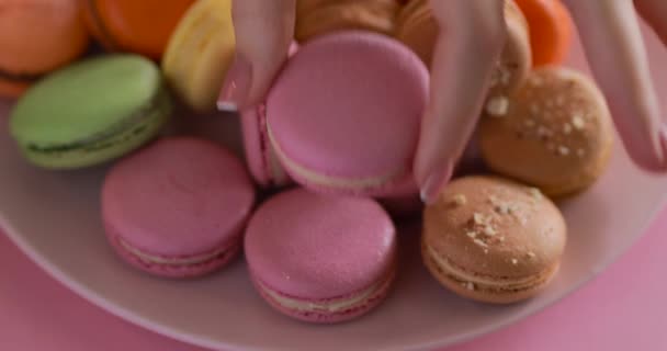 Female hand put a one pink macaroon — Αρχείο Βίντεο