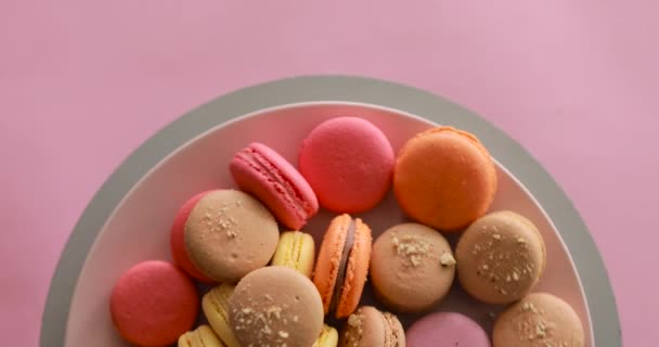 Female hand take one macaroon from rotating colorful cakes set — Stockvideo