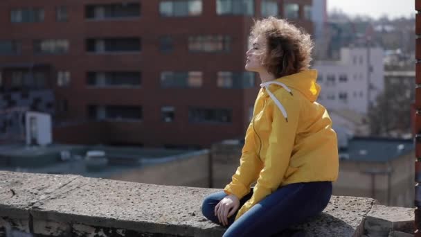 Woman sitting and relaxing on the roof — Stock video