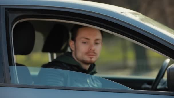 Man met chirurgisch masker kijkend door het raam in een auto — Stockvideo