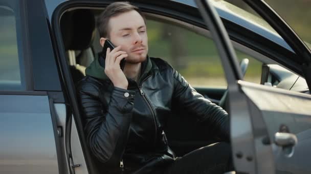 Ο άνθρωπος μιλάει τηλεφωνικά σε ένα αυτοκίνητο. — Αρχείο Βίντεο