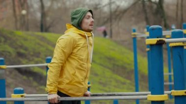 Parktaki yatay çubuklarda şınav çeken adam