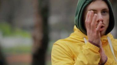 Sportif adam dışarıda ellerini ısıtıyor.