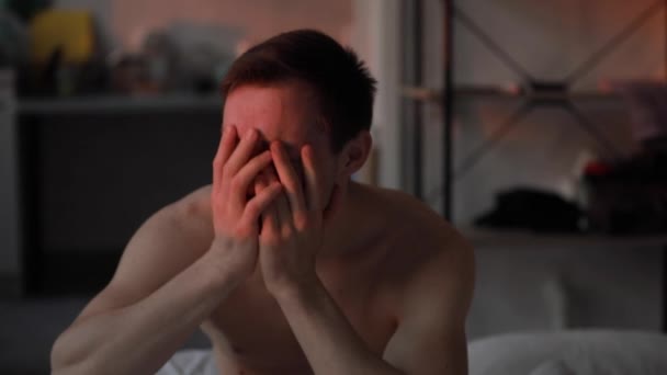 Мужчина смеется в постели, как сумасшедший пациент — стоковое видео