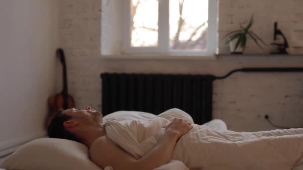Ο άνθρωπος κοιμάται σε ένα κρεβάτι — Αρχείο Βίντεο