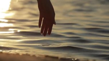 Kadın elinin silueti elini suya soktu.