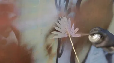 Painting wall with stencil in palm leaf shape