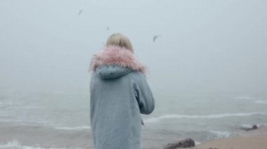 Mutlu kadın deniz iskelesinde yürüyor