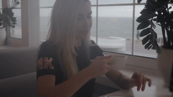 Vacker kvinna dricka te i café — Stockvideo