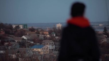 Şapkalı güzel kadın akşam manzarasına bakıyor.