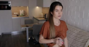 Kadın evinde su içiyor.