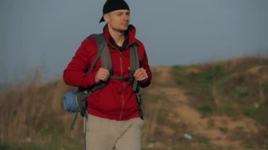 Turist büyük bir sırt çantasıyla doğa yürüyüşü yapıyor.
