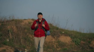 Turist büyük bir sırt çantasıyla doğa yürüyüşü yapıyor.