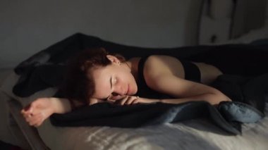 Sabahın erken saatlerinde, tatlı bir kadın bir yatakta uyanır.