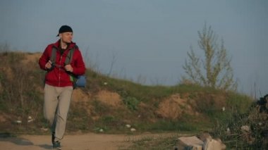 Turist büyük bir sırt çantasıyla doğa yürüyüşü yapıyor.