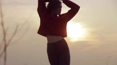 Gün batımında dans eden kadın silueti